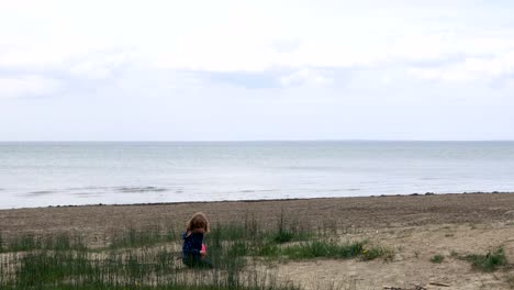 Niña-jugando-en-la-arena-del-lago-Ontario-corre-hacia-la-cámara