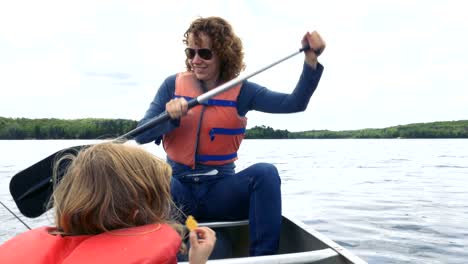 Frau-ein-Ruderboot-mit-einem-Kind-sitzen-vorne