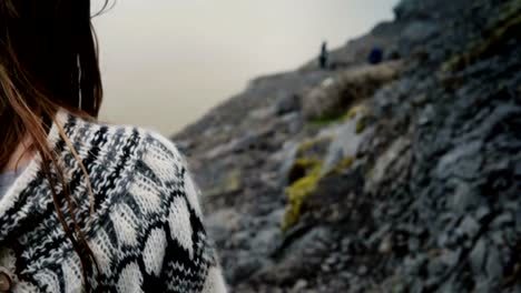 Close-up-view-of-brunette-female-hair-waving-on-the-wind.-Young-woman-in-lopapeysa-sweater-hiking-in-the-mountains