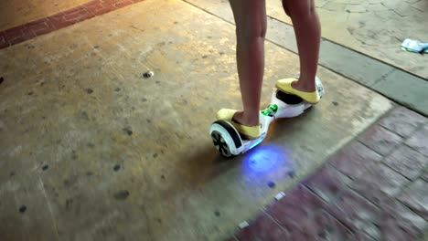 Mädchen-mit-Hoverboard,-ein-selbstbalancierende-Zweirad-Board.-Der-Kreisel-basierte-Doppelrad-Elektroroller-nennt-man-auch-eine-intelligente-Unruh.