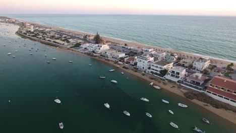 Fliegen-über-dem-Faro-Strand-(Praia-de-Faro)-bei-Sonnenuntergang,-Algarve,-Portugal