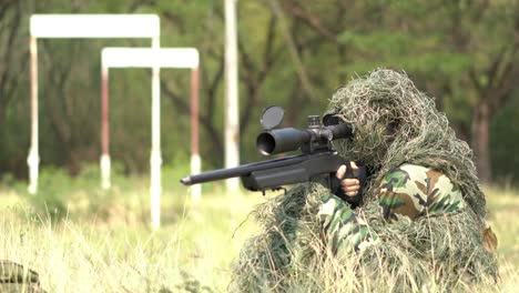 Sniper-soldier-lying-on-the-ground-and-camouflage-in-grass.-Soldier-holding-gun-weapon-and-waring-armor-uniform.-The-military-is-responsible-for-maintaining-the-territory.
