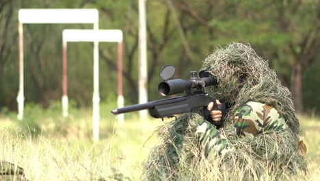 Francotirador-soldado-tendido-en-el-suelo-y-camuflaje-en-hierba.-Soldado-con-arma-pistola-y-waring-armadura-uniforme.-El-ejército-es-responsable-de-mantener-el-territorio.