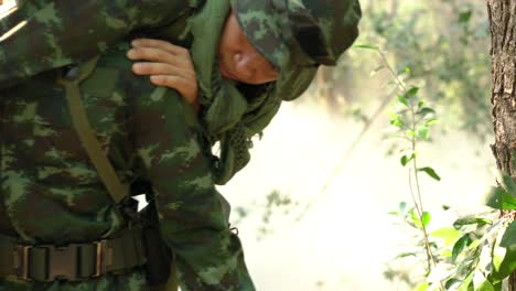 Soldier-holding-gun-weapon-and-waring-armor-uniform-with-smoke.-Soldiers-are-taking-the-wounded-man-out-of-the-jungle.