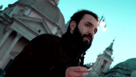 Thoughtful-handsome-man-smoking-a-cigarette-in-the-city,waiting-for-someone