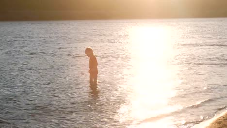 Boy-in-a-red-t-shirt-walks-on-the-river-water.