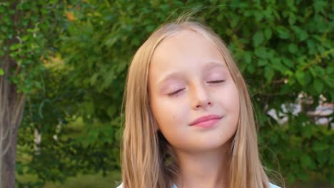 Adorable-girl-gesturing-and-touching-blonde-hair-with-smile-on-face