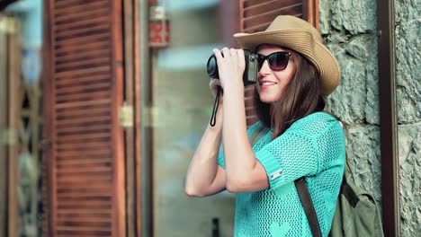 Fotógrafo-joven-turista-en-gafas-de-sol-y-sombrero-tomar-fotos-con-cámara-profesional