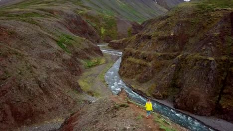 Amazing-drone-point-of-view-of-woman-hiking-on-mountain-ridge-over-canyon-in-Iceland