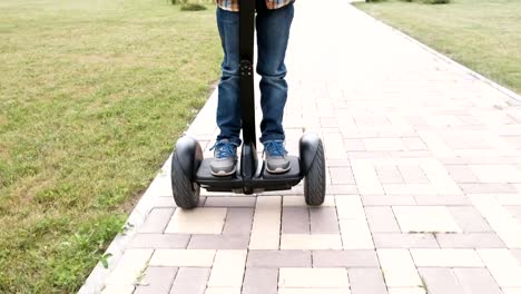 Nicht-erkennbare-junge-rollt-auf-Gyro-Roller-in-der-Nähe-der-Wohnung.-Nahaufnahme-der-Beine.