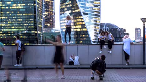 young-people-taking-pictures-of-each-other-on-the-background-of-modern-buildings,-time-lapse