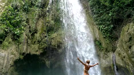 Girl-embracing-beautiful-waterfall-in-the-Philippines--4K