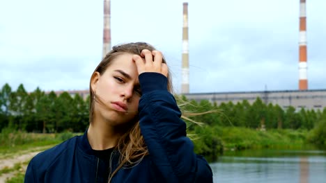 Portrait-of-a-young-girl-against-a-hydroelectric-plant.