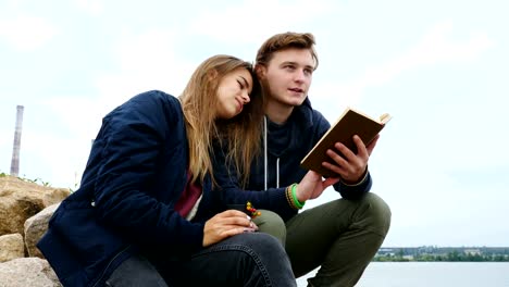 A-guy-with-a-girl-is-sitting-on-the-river-bank-and-drinking-tea.