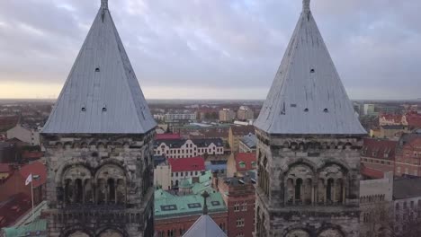 Luftaufnahme-des-Dom-zu-Lund-Türme.-Drohne-Schuss-fliegt-zwischen-die-Kirchtürme-in-der-Stadt-Lund,-Schweden