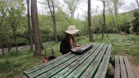 young-and-beautiful-woman-playing-synthesizer-on-the-table-of-a-park,--France