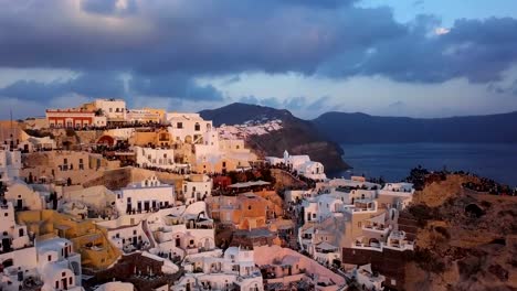 Sobrevuelo-de-la-ciudad-de-Oia-antes-de-puesta-del-sol,-isla-de-Santorini,-Grecia