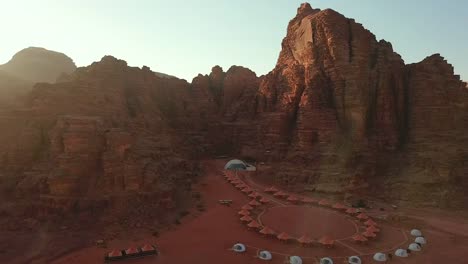 Aerial-view-of-camping-tents-and-dome-tents-along-the-rock-in-Wadi-Rum-desert,-Jordan