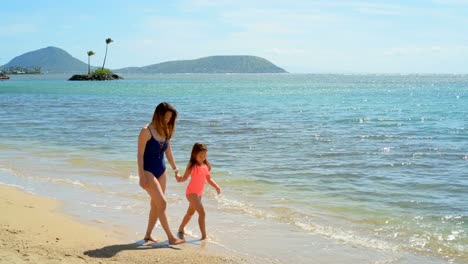 Mother-and-daughter-walking-on-the-beach-4k