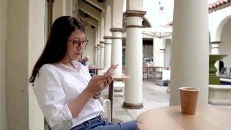 Frau-SMS-auf-Handy-in-einem-Café.