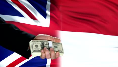 Great-Britain-and-Indonesia-officials-exchanging-tank-for-money,-flag-background