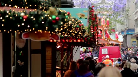 Pull-Focus-through-Twinkling-Xmas-Lights,-Large-Crowd-German-Christmas-Market