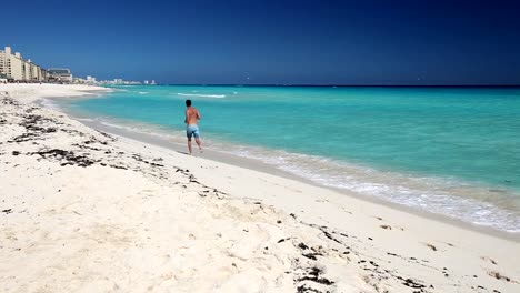 Atlético-hombre-para-correr-en-la-playa-caribeña,-Cancún