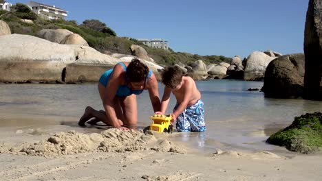 Mutter-und-Kind-spielen-mit-Spielzeug-am-Strand,-Cape-Town