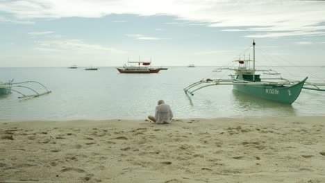 Mädchen-sitzt-am-Strand