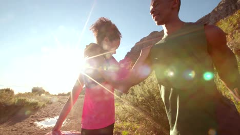 Young-afro-american-couple-warming-up-before-running-outdoors