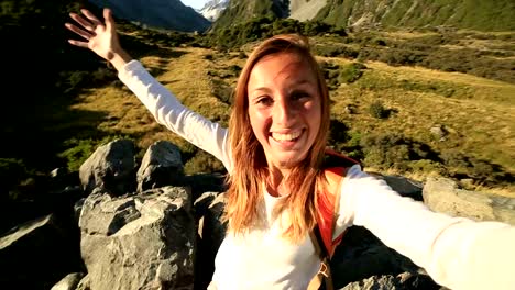 Young-woman-takes-self-portrait-on-mountain-background