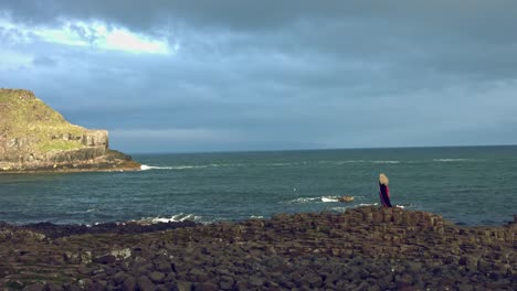 4k-Fantasy-Shot-on-Giant's-Causeway-of-a-Queen-Standing-in-Wind