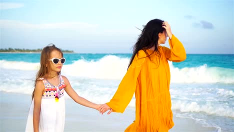 Little-adorable-girl-and-young-mother-at-tropical-beach