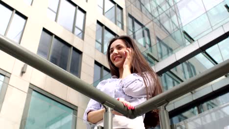 Girl-with-long-hair-talking-on-the-phone-in-city.