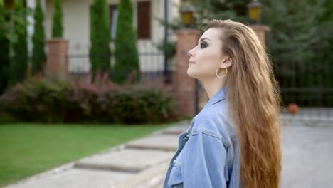 Side-view-of-confident-brunette-with-makeup-wearing-casual-clothing-walking-at-street-looking-away