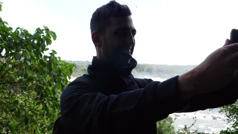 Guy-taking-a-selfie-in-Iguacu-Falls,-Brazil