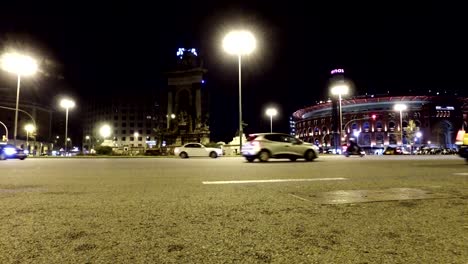 Nachtverkehr-am-Plaza-de-Espagna-mit-Blick-auf-die-Altstadt-Arena-Gebäude-in-Barcelona,-Katalonien,-Spanien