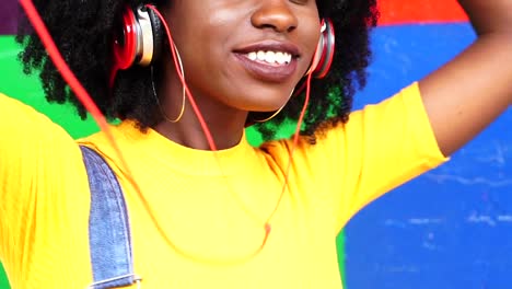 Escuchar-música-de-chica-guapa-con-sus-auriculares-con-colores-de-fondo