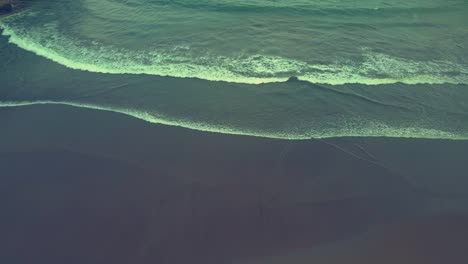 Waves-folding-and-touching-the-shores-of-Baron-beach-aerial-view,-Indonesia