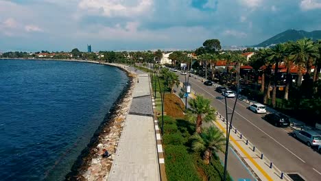 Drone-flying-over-the-coast-line-4k.-Aerial-view-of-sea-waves,-street-and-city-buildings.