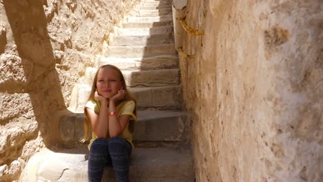 Mädchen-sitzen-auf-der-Treppe-am-Beige-Steintreppen-und-denken