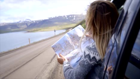 Junge-Frau-im-Auto-Blick-auf-Karte,-Road-Trip-Konzept-Urlaub