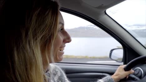 Mujer-joven-en-el-coche-cantando-y-bailando,-carretera-viaje-concepto-vacaciones---cámara-lenta