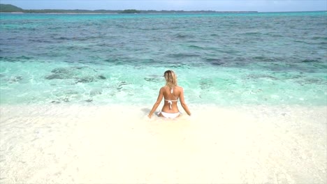 Junge-Frau-entspannt-auf-einem-tropischen-Strand-spielen-und-Planschen-mit-Wasser