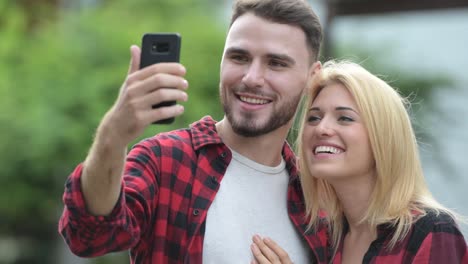 Junge-Brautpaar-nehmen-Selfie-zusammen-in-den-Straßen-im-freien