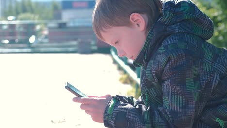 Boy-types-and-sends-a-message-on-a-mobile-phone.