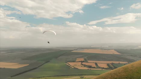 Atleta-paraglider-vuela-en-su-parapente-junto-a-las-golondrinas.-Seguimiento-desde-los-aviones-no-tripulados