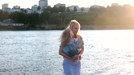 Mother-and-daughter-on-the-river-in-the-city.-Mother-spinning-with-her-daughter-in-her-arms.