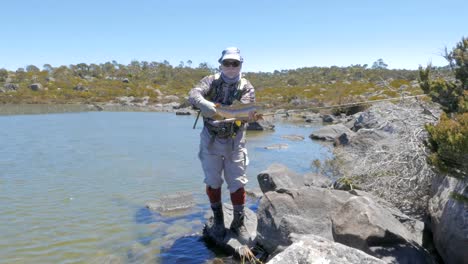 zoom-rápida-en-la-captura-de-un-pescador-sosteniendo-una-gran-trucha-marrón