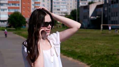 Young-woman-talking-mobile-phone-walking-in-stadium.